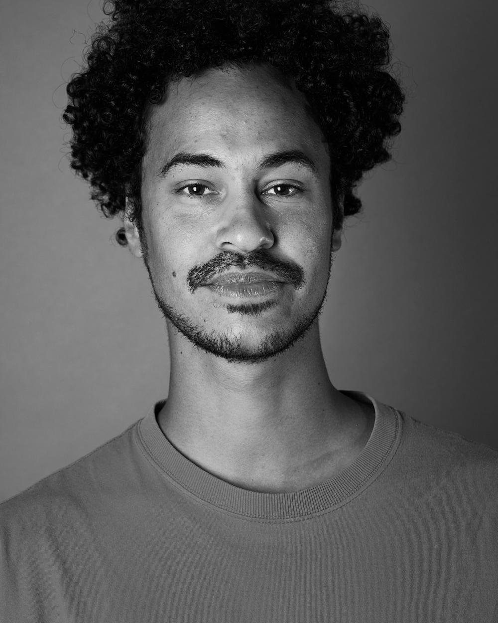 Dansaren Yared Tilahun Cederlund klädd i tröja med mörkt kort skägg och lockigt mörkt hår.