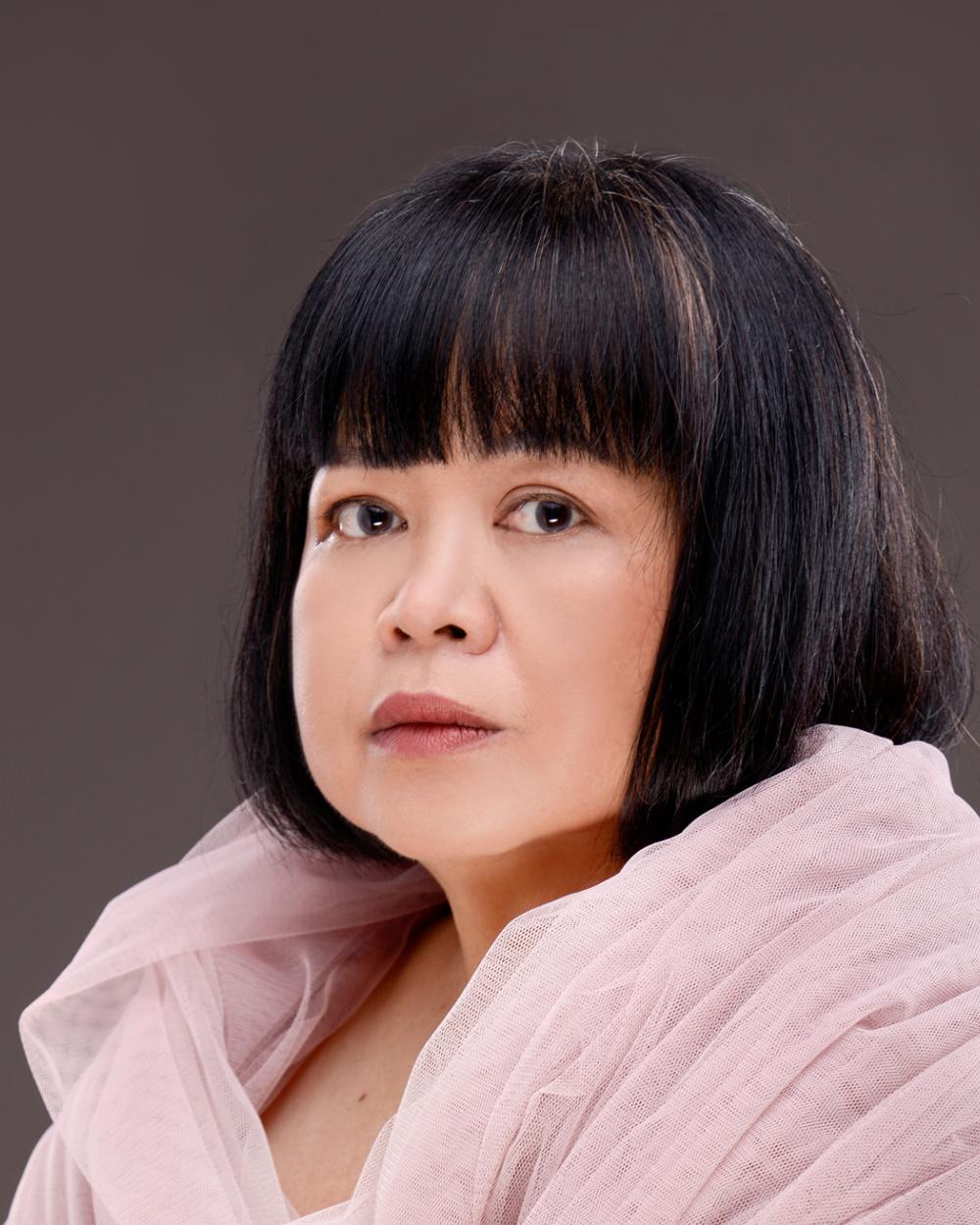 Konstnären Melati Suryodarmo i ljusrosa skir sjal med kortklippt svart hår.