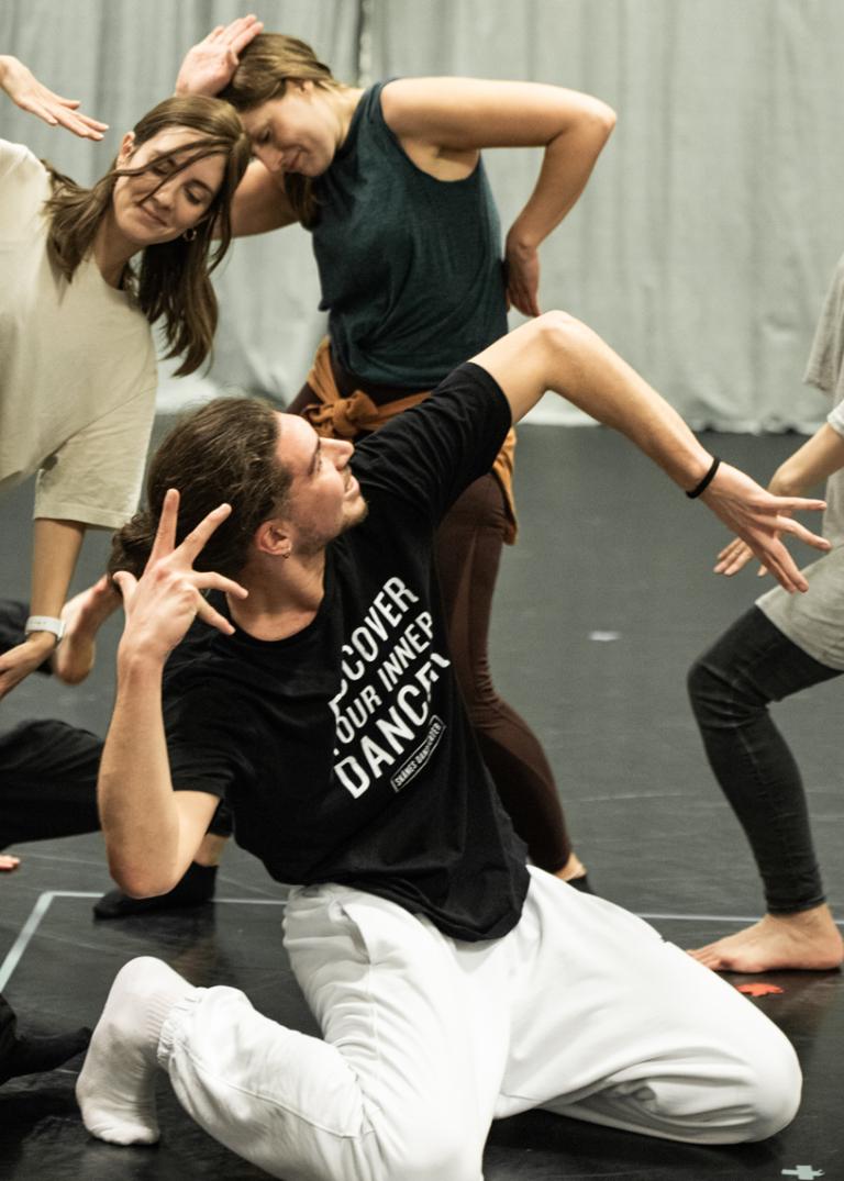 6 personer i olika åldrar som gör yviga gester tillsammans under en workshop med swop.