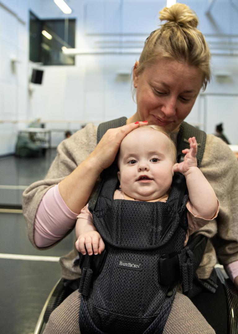 Skånes Dansteater Madeleine i dansstudion med bebis i bärsele.