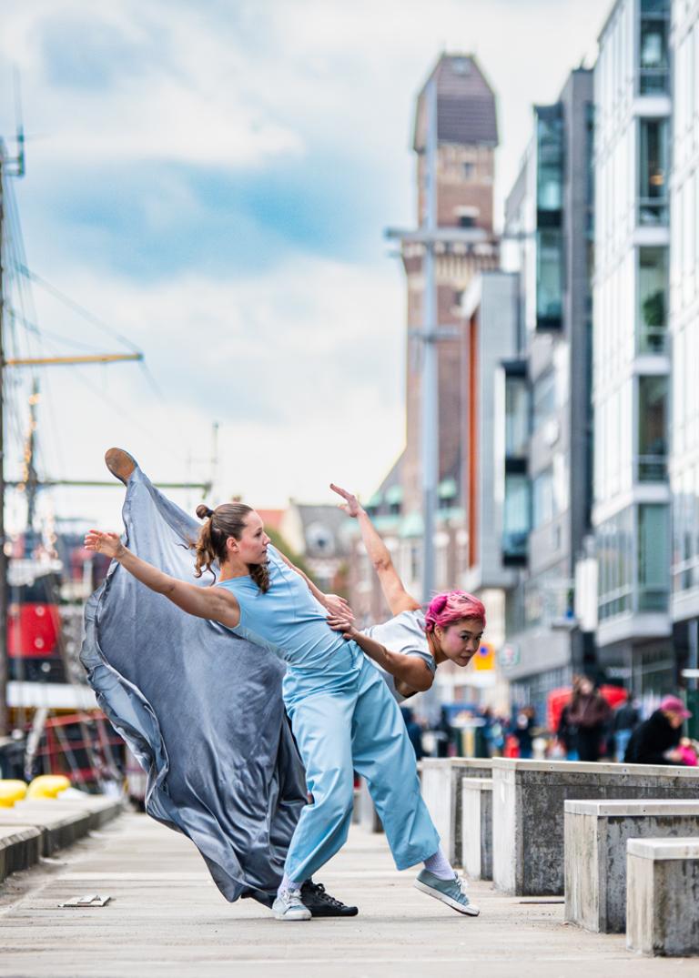 Dansaren Jeanne i ljusblå kläder dansar tillsammans med dansaren Kat i vid ljusblå kjol vid kajkanten i Malmö hamn.
