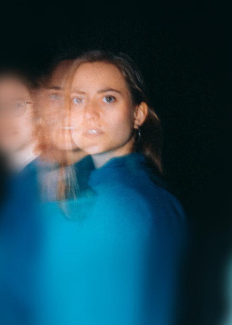 Dansare klädda i olika nyanser av blått rör sig förbi. 