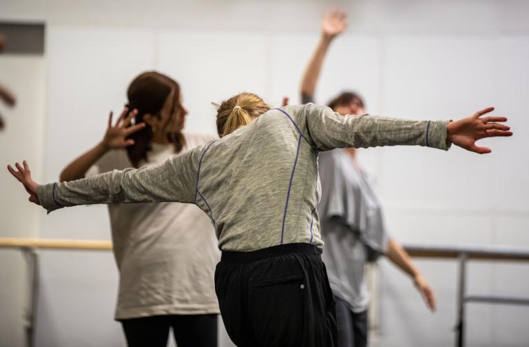 Tre workshopdeltagare i bekväma kläder som dansar i vår dansstudio.