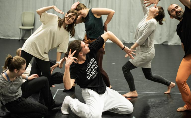 6 personer i olika åldrar som gör yviga gester tillsammans under en workshop med swop.