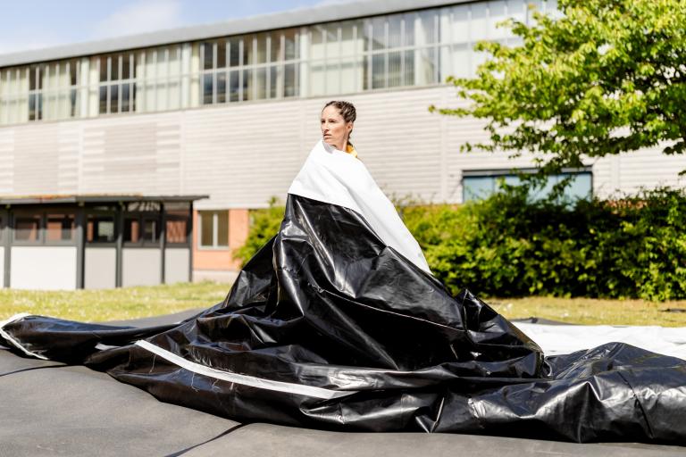 Skånes Dansteaters dansare Maria Pilar Abaurrea Zardoya insvept ett enormt glansigt svart och vitt plastskynke i dansföreställningen UP-AND-DOWN-AND-UP- av koreografen Jernej Bizjak.