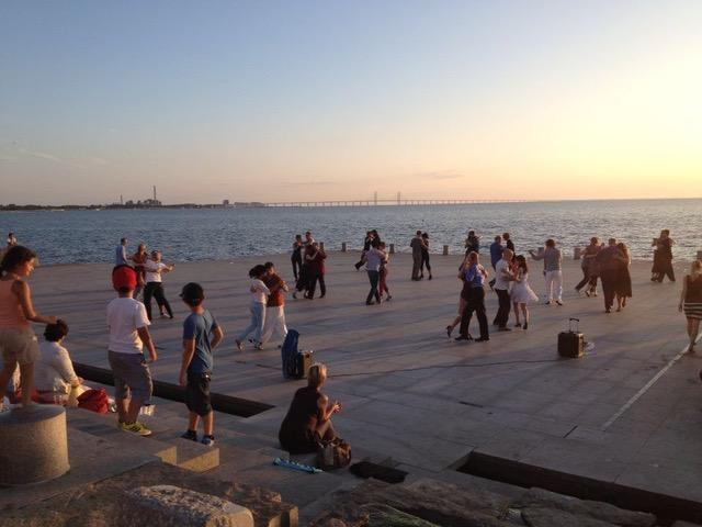 Ett tiotal par dansar tango på Scaniaplatsen vid havet i Malmös Västra hamnen.