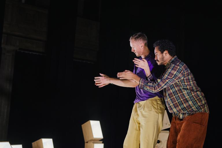 Dansarna Viktor och Yared dansar bredvid varandra och för armarna nära framför sig.