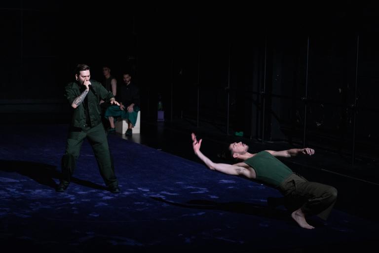 Dansaren Fabrizio di Franco böjer sig bakåt på huk framför beatboxaren Mattias Ümit Yilbar Norgren i föreställningen Like the Shadow I am and I am not av Ina Christel Johannessen.