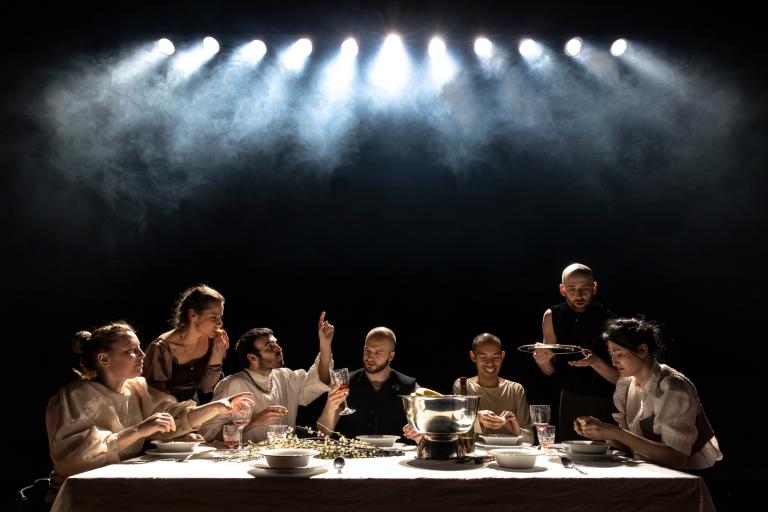 Skånes Dansteaters dansare sitter vid ettlångt bord dukat för fest. De äter, pratar, skrattar och dricker.