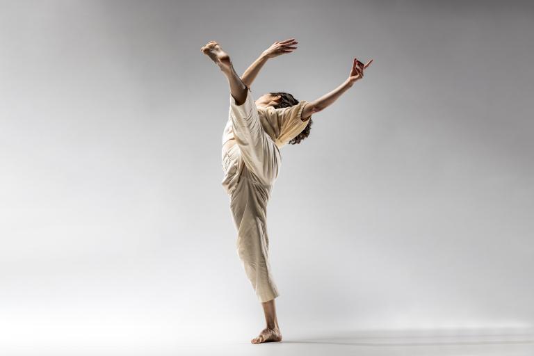 Skånes Dansteaters dansare Maria Pilar sträcker ett ben högt upp i luften, och snurrar bakåt med armarna i luften.