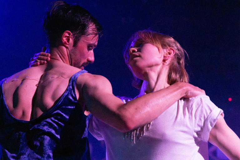 Dansarna Emma och Kit dansar tillsammans med en hand på den andres nacke i Skånes Dansteaters dansföreställning Indigo Flamingo.