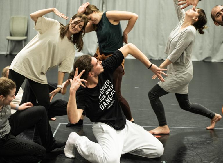 6 personer i olika åldrar som gör yviga gester tillsammans under en workshop med swop.