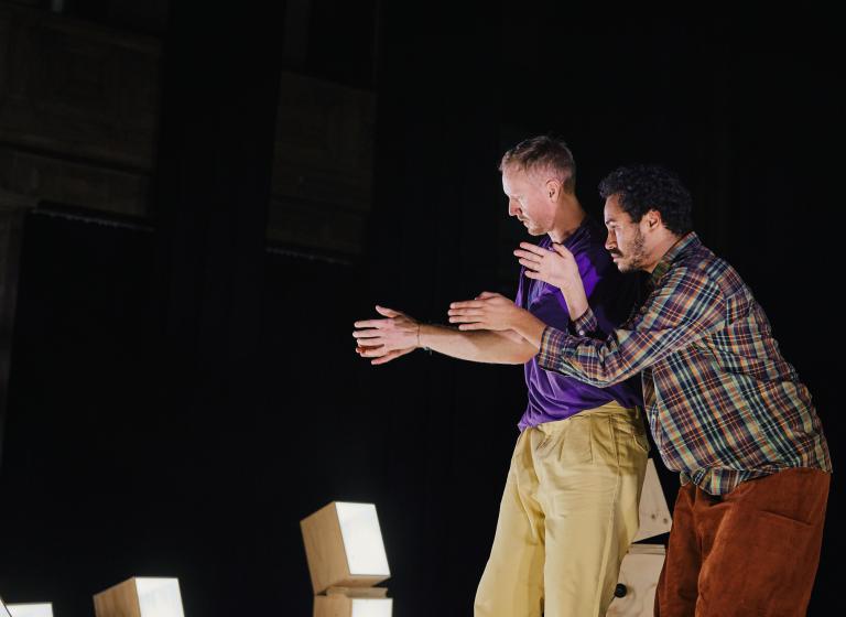 Dansarna Viktor och Yared dansar bredvid varandra och för armarna nära framför sig.