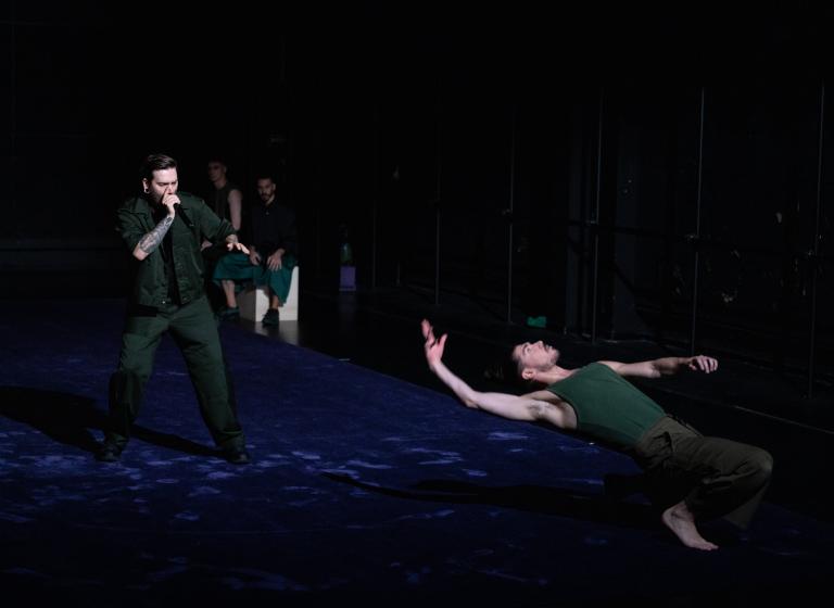 Dansaren Fabrizio di Franco böjer sig bakåt på huk framför beatboxaren Mattias Ümit Yilbar Norgren i föreställningen Like the Shadow I am and I am not av Ina Christel Johannessen.