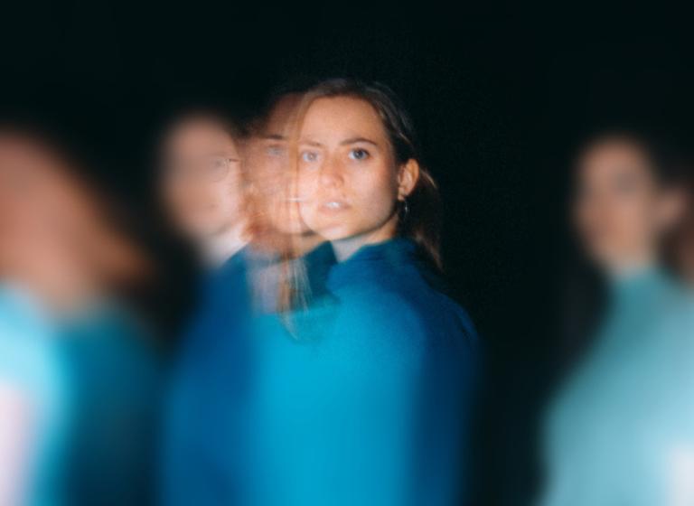 Dansare klädda i olika nyanser av blått rör sig förbi dig.