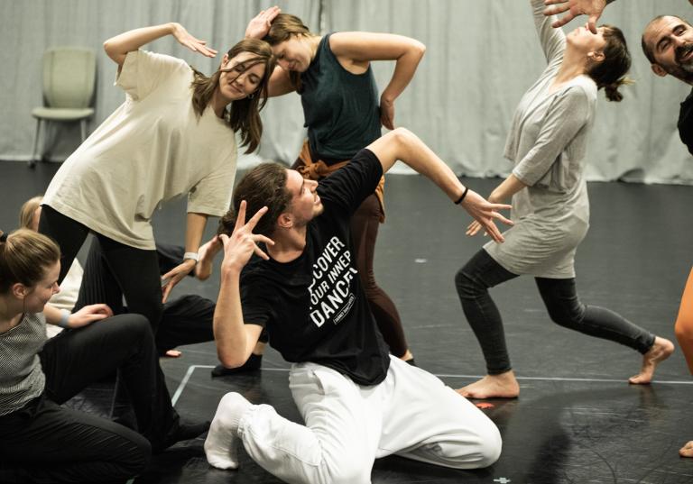6 personer i olika åldrar som gör yviga gester tillsammans under en workshop med swop.