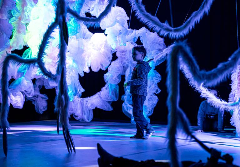Ett barn i Dalija Acin Thelanders dansföreställning Fields of Tender för barn med interllektuella eller neuropsyktiatriska funktionsvariationer.