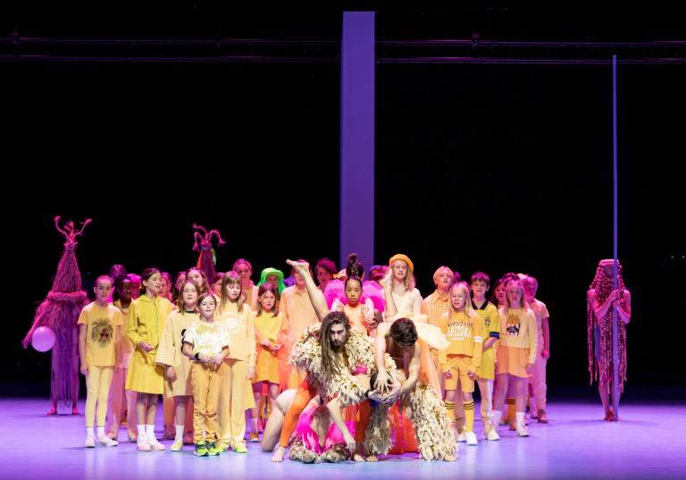 Dansarna Oscar, Iris och Yiorgos står framför barnkören som sjunger klädda i gult i Skånes Dansteaters dansföreställning Out of the Blue.