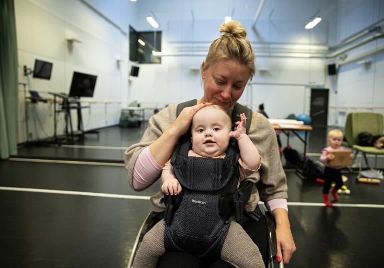 Skånes Dansteater Madeleine i dansstudion med bebis i bärsele.