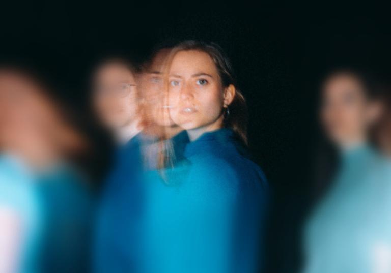 Dansare klädda i olika nyanser av blått rör sig förbi dig.