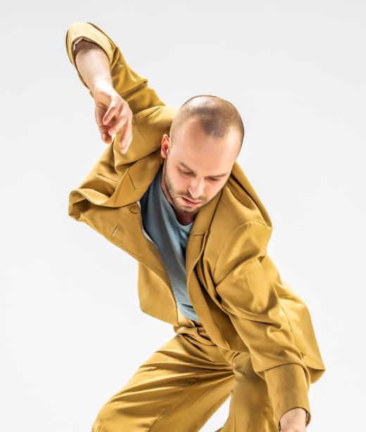 Bild på dansaren Tomas Cervinka i senapsgula kläder.