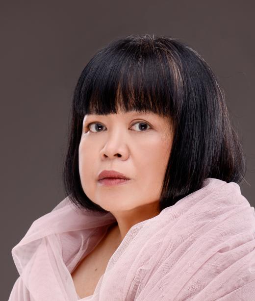 Konstnären Melati Suryodarmo i ljusrosa skir sjal med kortklippt svart hår.